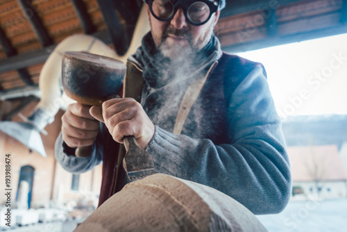 Stonemason chiseling stone in his workshop photo