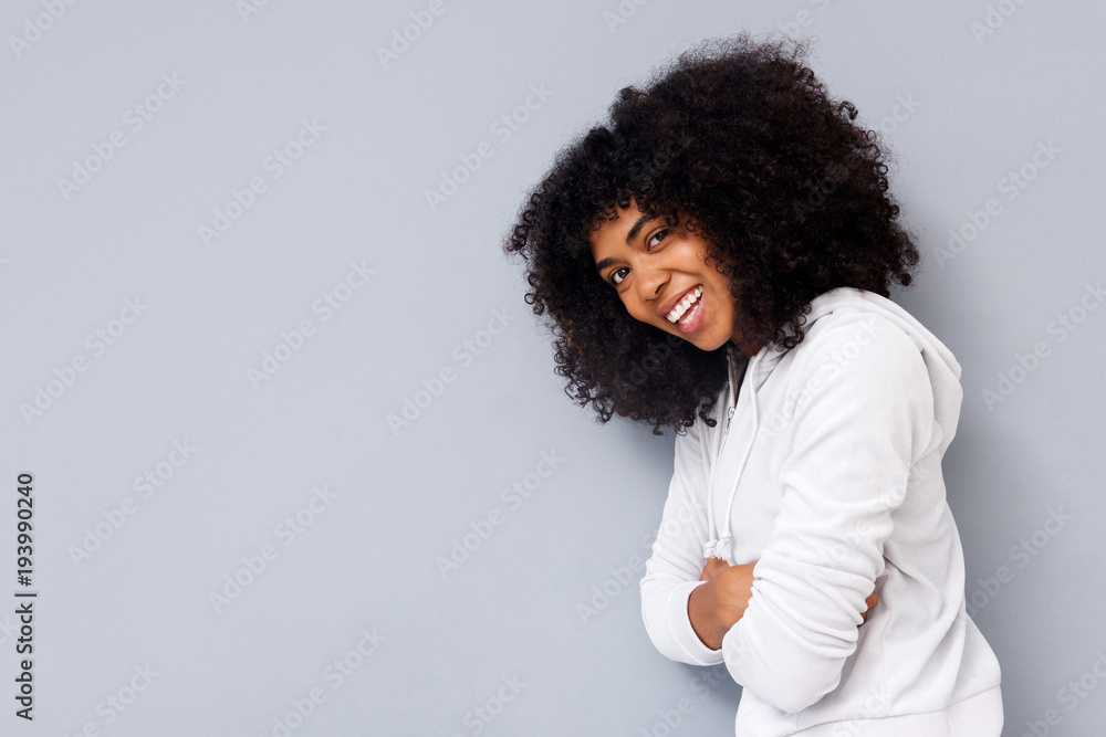 young african american woman smiling against gray background young african american woman smiling against gray background
