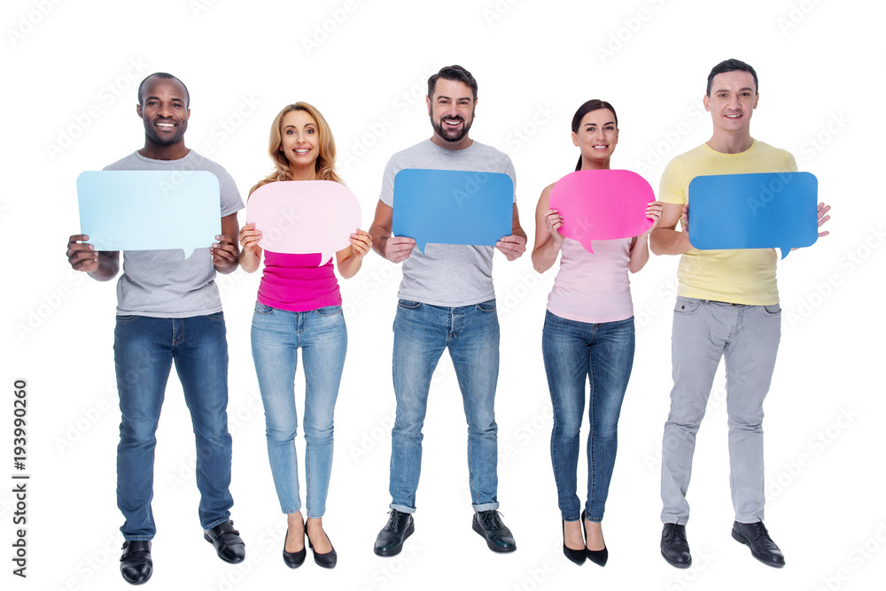 Inspiration. Good-looking cheerful young best friends smiling and holding tables and standing in a line and wearing casual clothes Inspiration. Good-looking cheerful young best friends smiling and holding tables and standing in a line and wearing casual clothes
