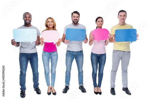 Inspiration. Good-looking cheerful young best friends smiling and holding tables and standing in a line and wearing casual clothes