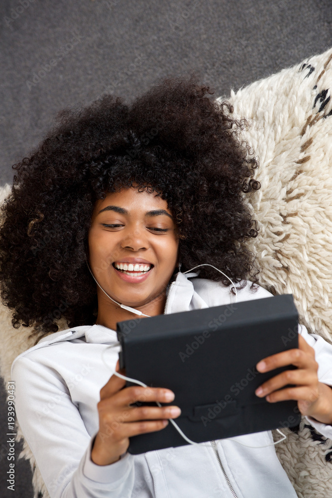 cheerful woman watching streaming video on digital tablet and smiling at home cheerful woman watching streaming video on digital tablet and smiling at home