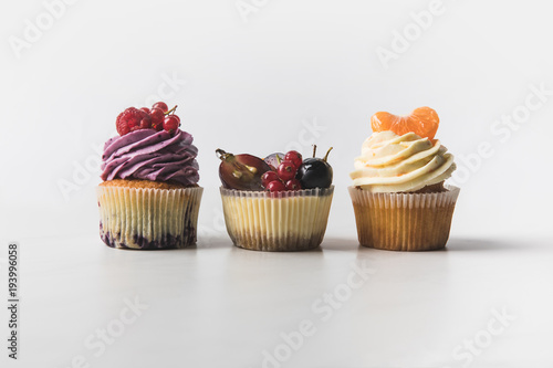 close up view of various sweet cupcakes isolated on white