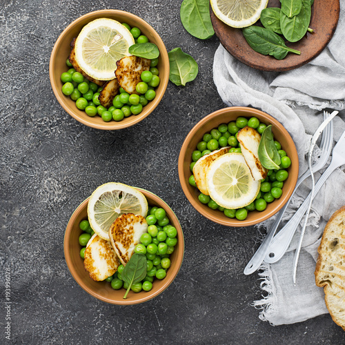Green young peas, cheese haloumi, lemon. orange salad with slices of bread. Top View
