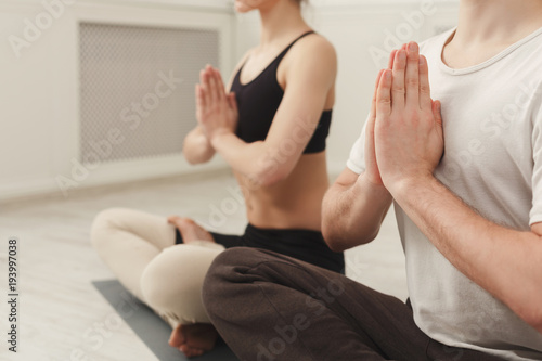 Young couple practicing yoga sitting in padmasana