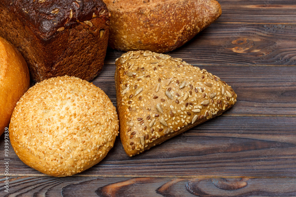 Naklejka premium Bakery background, bread assortment on black wooden backdrop. Top view with copy space