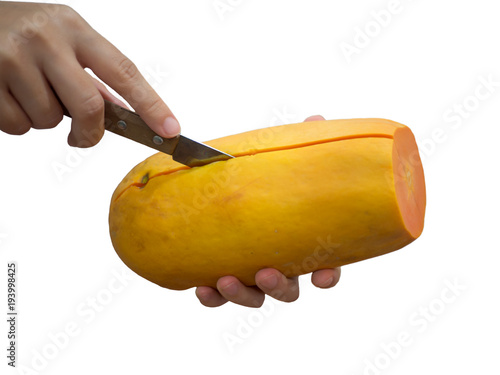 Two hands are cutting papaya with a knife on isolated white background photo