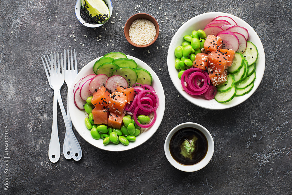 Fresh seafood recipe. Shrimp salmon poke bowl with fresh prawn, brown rice, cucumber, pickled sweet onion, radish, soy beans edamame portioned with black and white sesame. Food concept poke bowl