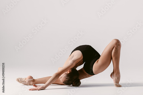 Fototapeta Naklejka Na Ścianę i Meble -  Young gymnast girl stretching and training