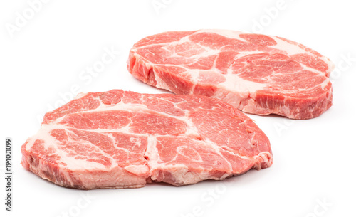 Two raw pork neck meat cuts isolated on white background fresh slices without bone .