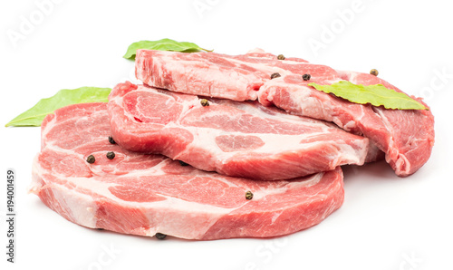 Three raw pork neck meat cuts with black pepper and three bay leaves isolated on white background fresh slices without bone .