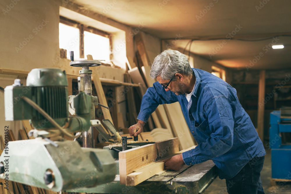 middle aged carpenter working in his workshop middle aged carpenter working in his workshop