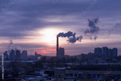 Smoke from a pipe factory against the background of the rising sun. Environmental problem of pollution of environment and air in large cities