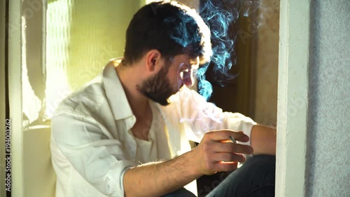 A man smokes a cigarette at home
