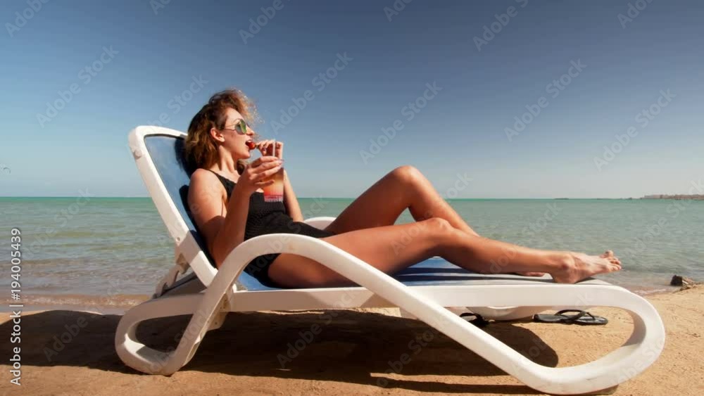Young girl in bikini on beach with party cocktail Young girl in bikini on beach with party cocktail