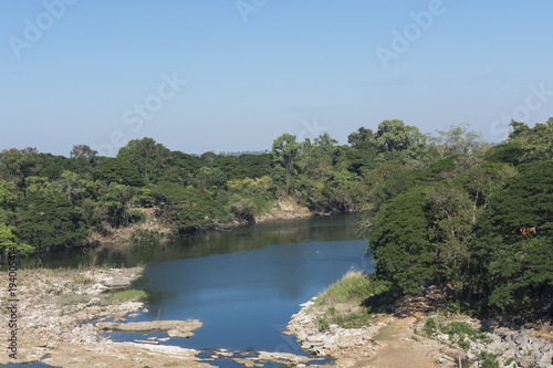 landscape behind the dam with forest and a river.