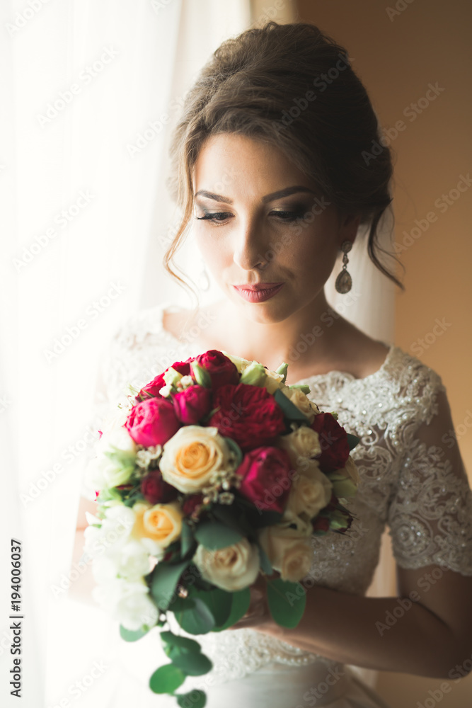 Beautiful bride wearing fashion wedding dress with feathers with luxury delight make-up and hairstyle, studio indoor photo shoot Beautiful bride wearing fashion wedding dress with feathers with luxury delight make-up and hairstyle, studio indoor photo shoot