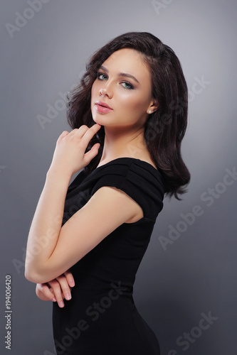 Young beautiful woman with fashion makeup, in black dress .