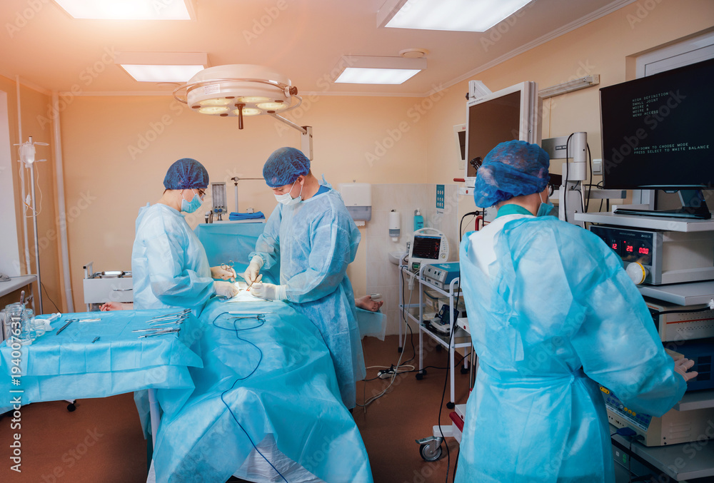 Group of surgeons in operating room with surgery equipment. Group of surgeons in operating room with surgery equipment.