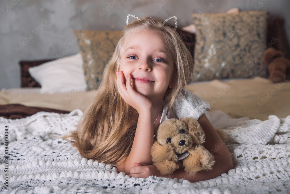 little girl lay in the bed with dog toy little girl lay in the bed with dog toy