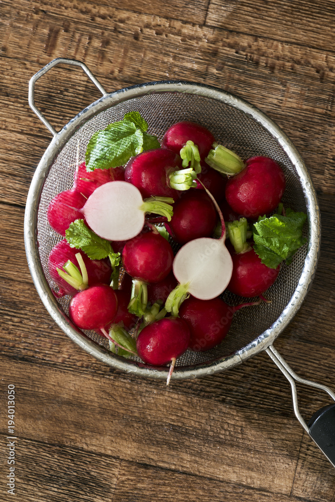 Several red radishes in a sieve Several red radishes in a sieve