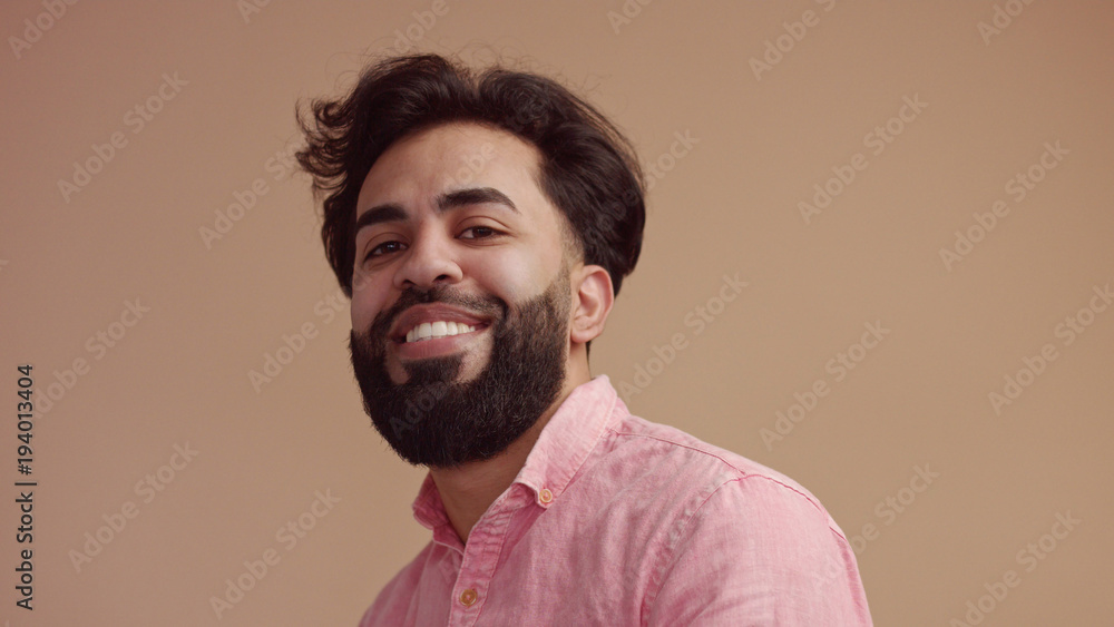 Fototapeta premium man touches his hair an looking at camera. Good groomed man with beard