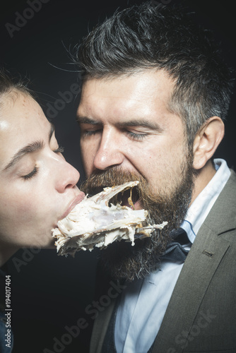 Man and woman with chickens skeleton in mouths, black background. photo