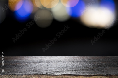 Empty wooden table platform on bokeh at nigh.