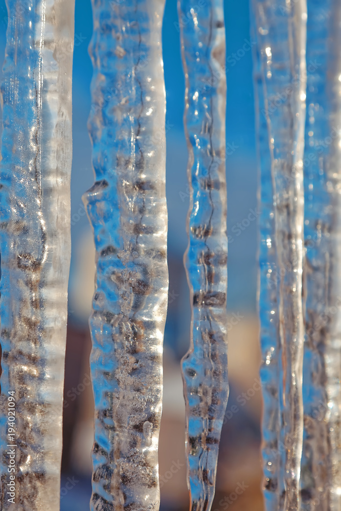 Bright transparent icicles against the background of the blue sky. Winter backdrop Bright transparent icicles against the background of the blue sky. Winter backdrop