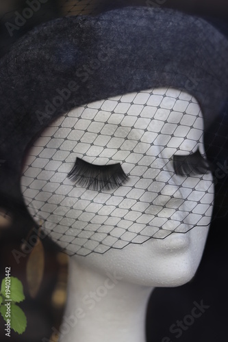 maniquí con pestañas y sombrero