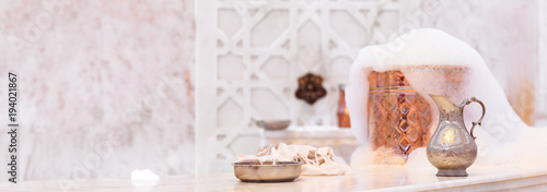 Water jar, towel and copper bowl with soap foam in turkish hamam. Traditional interior details