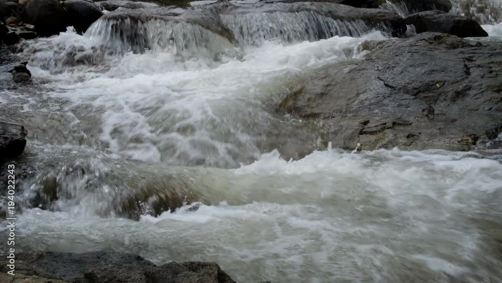 Close up.Pure fresh water waterfall in forest with black rocks. Close up.Pure fresh water waterfall in forest with black rocks.