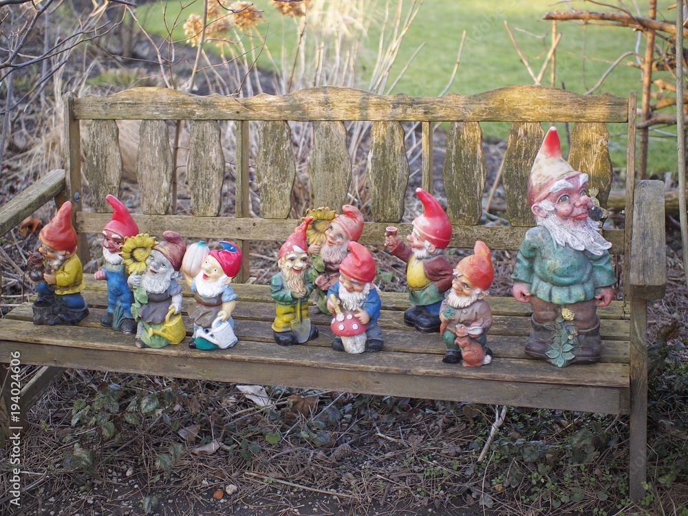 Deko - bunte Gartenzwerge stehen auf Holzbank Stock-Foto | Adobe Stock