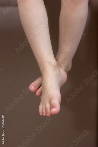 Baby feet. Kid toes while kid sitting on the chair.