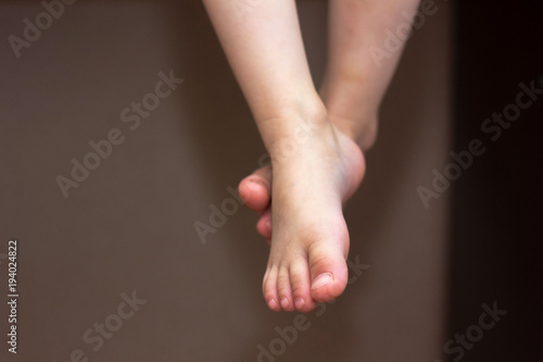 Baby feet. Kid toes while kid sitting on the chair. © sharafmaksumov