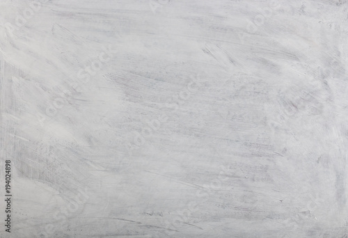 White washed painted textured abstract background with brush strokes in gray and black shades.