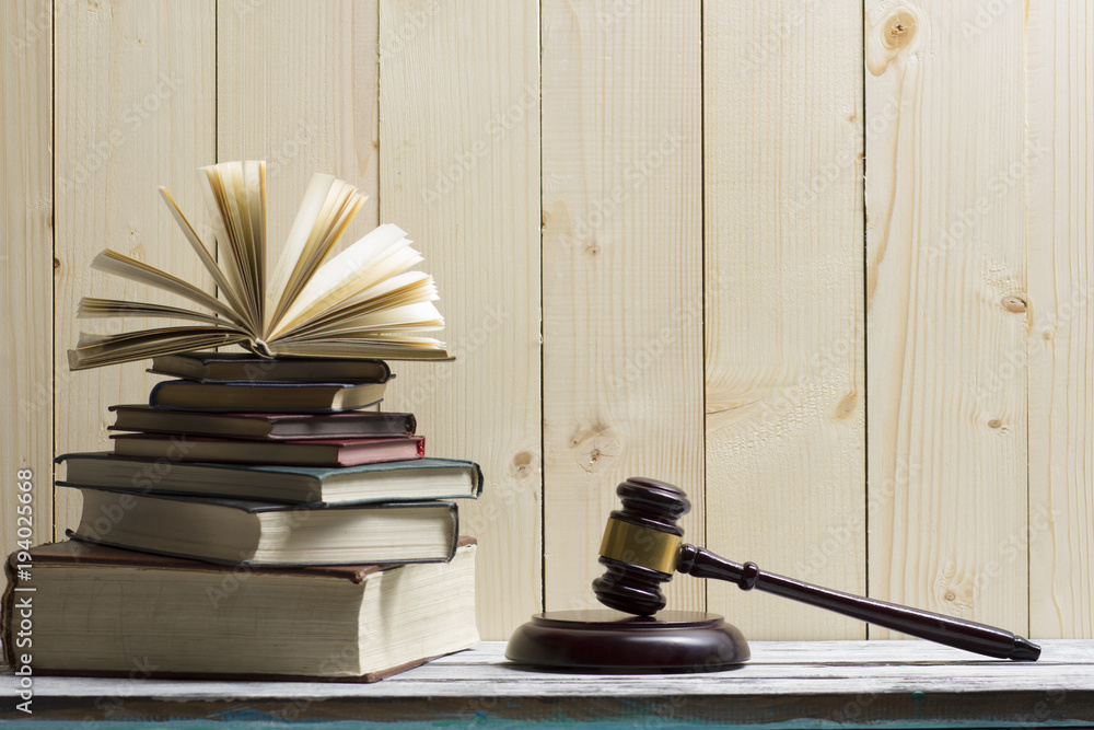 Legal Law concept - Open law book with a wooden judges gavel on table in a courtroom or law enforcement office. Copy space for text Legal Law concept - Open law book with a wooden judges gavel on table in a courtroom or law enforcement office. Copy space for text