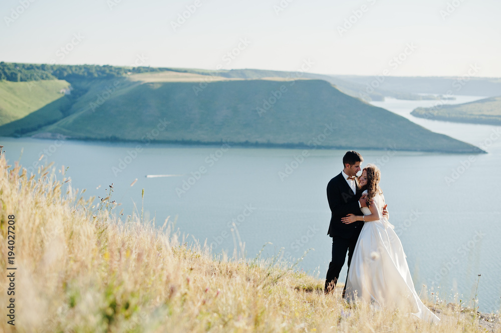 Wedding couple at breathtaking landscape with rock and lake. Wedding couple at breathtaking landscape with rock and lake.
