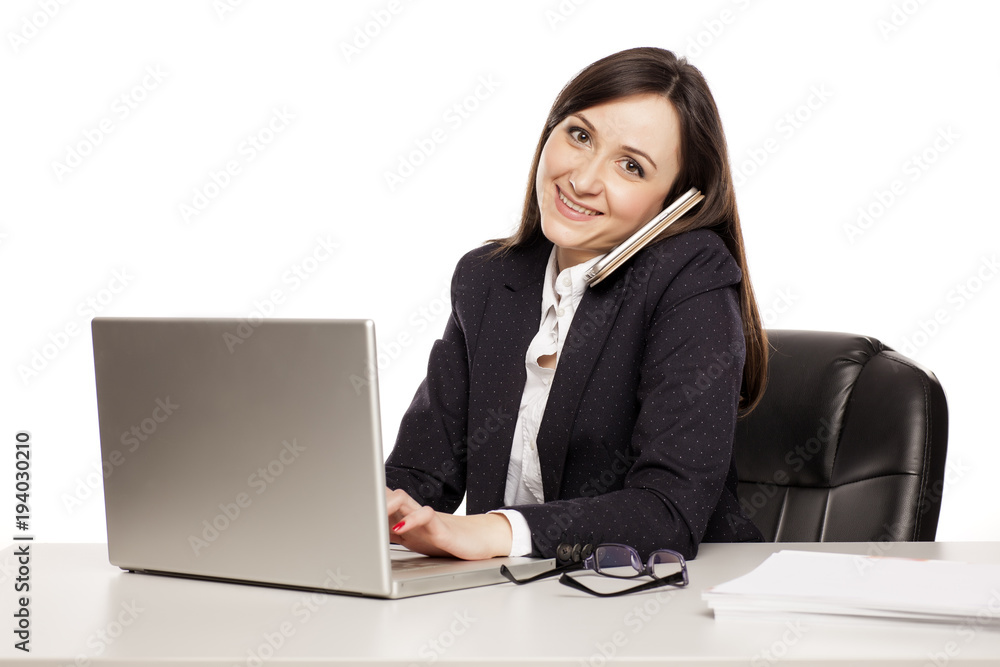 young smiling business woman working at a desk with a laptop young smiling business woman working at a desk with a laptop