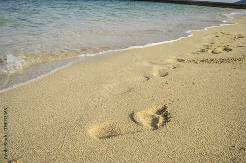 Mediterranean scene, shore of the Mediterranean Sea with barefoot footprints of people in summer