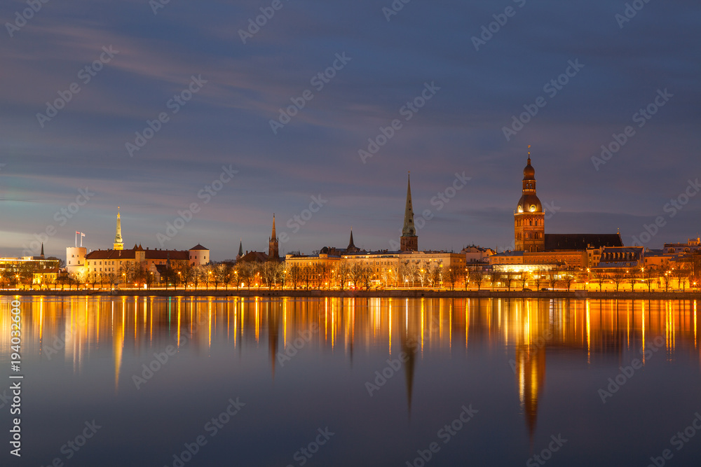 Skyline of old town of Riga seen across the river Daugava at night.