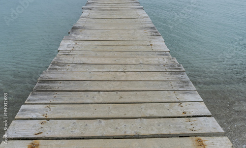 Wooden pier next to the Mediterranean sea on the island of Ibiza in Spain, holiday and summer scene