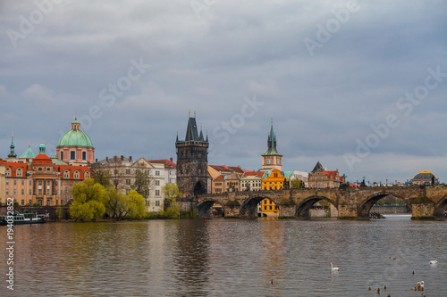 Charles bridge in gloomy day, Prague, Czech Republic. Water front of old museums.
