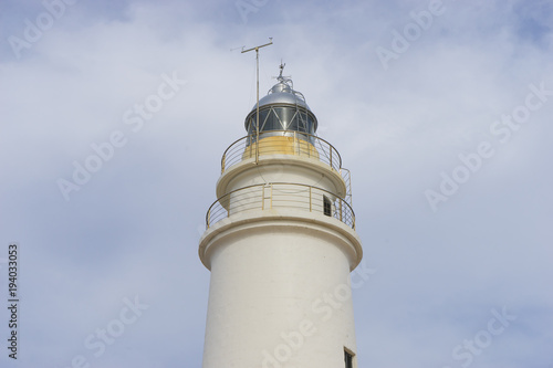 lighthouse next to the Mediterranean Sea, blue sky without clouds with calm waters. serves to warn ships of the presence of rocks