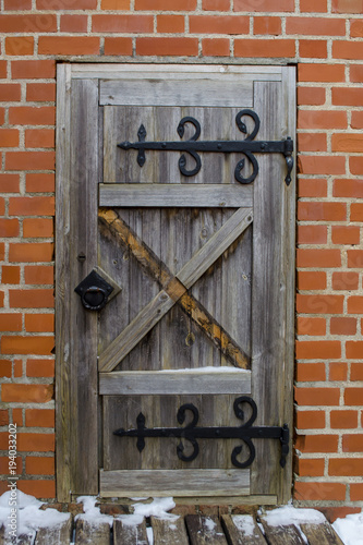 Medieval castle wooden door with massive iron hinges.