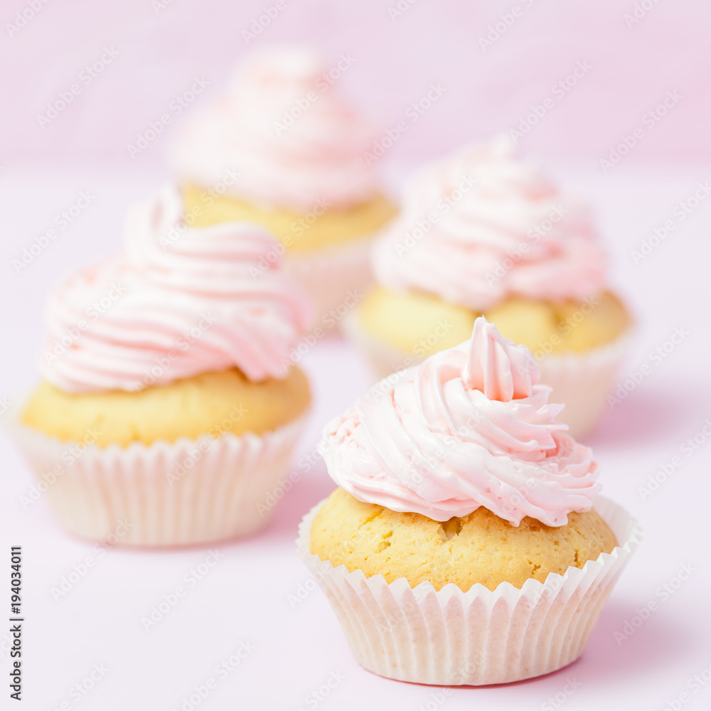 Cupcake decorated with pink buttercream on pastel pink background. Sweet beautiful cake. Square banner, greeting card for birthday, wedding, women's day. Close up photography. Selective focus Cupcake decorated with pink buttercream on pastel pink background. Sweet beautiful cake. Square banner, greeting card for birthday, wedding, women's day. Close up photography. Selective focus