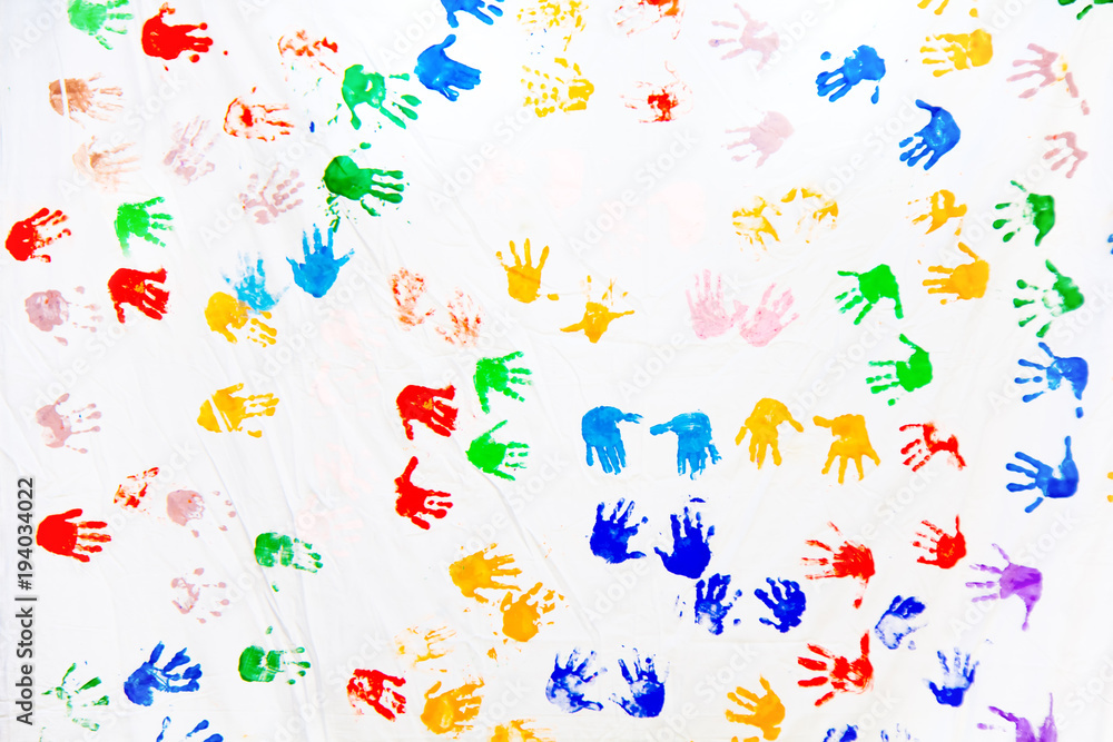 Color prints of children's hands on a white canvas. Imprint of the children's palm on the canvas. Prints of colored hands. Many children's colorful hands. Color prints of children's hands on a white canvas. Imprint of the children's palm on the canvas. Prints of colored hands. Many children's colorful hands.