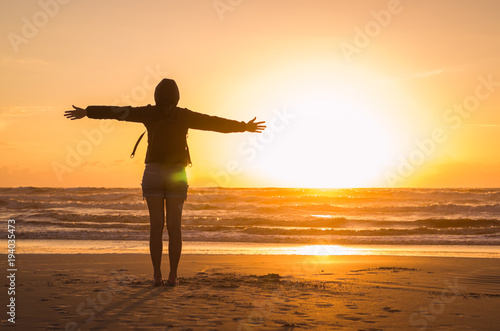 Woman looking at the horizon  beach at sunset