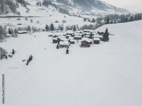 Aerial view of small houses in snow covered landscape in Swiss alps in Canton of Wallis