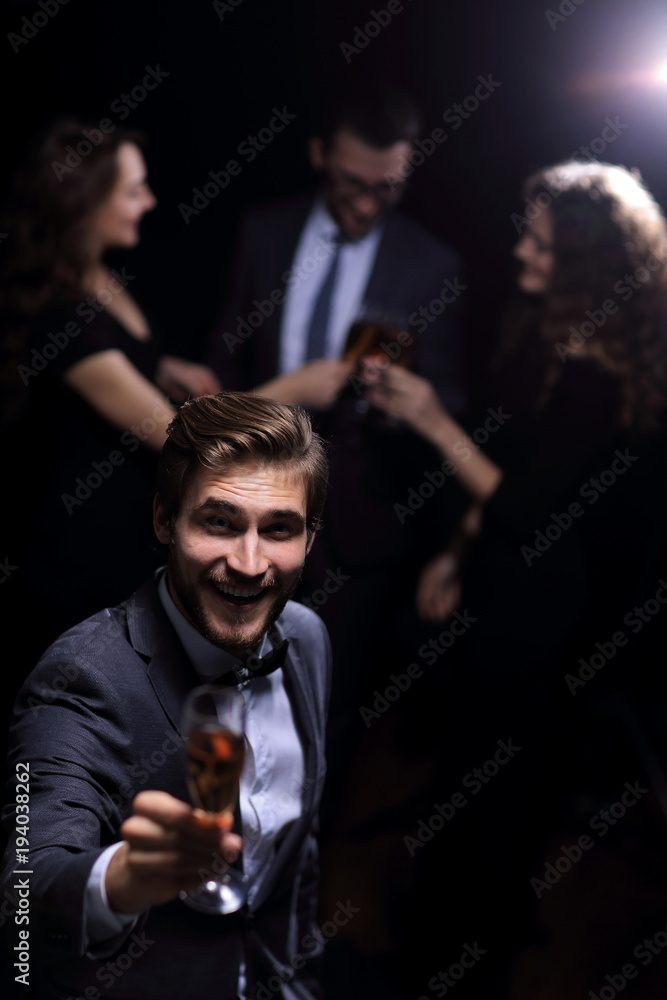 stylish young man standing with a glass of champagne. stylish young man standing with a glass of champagne.