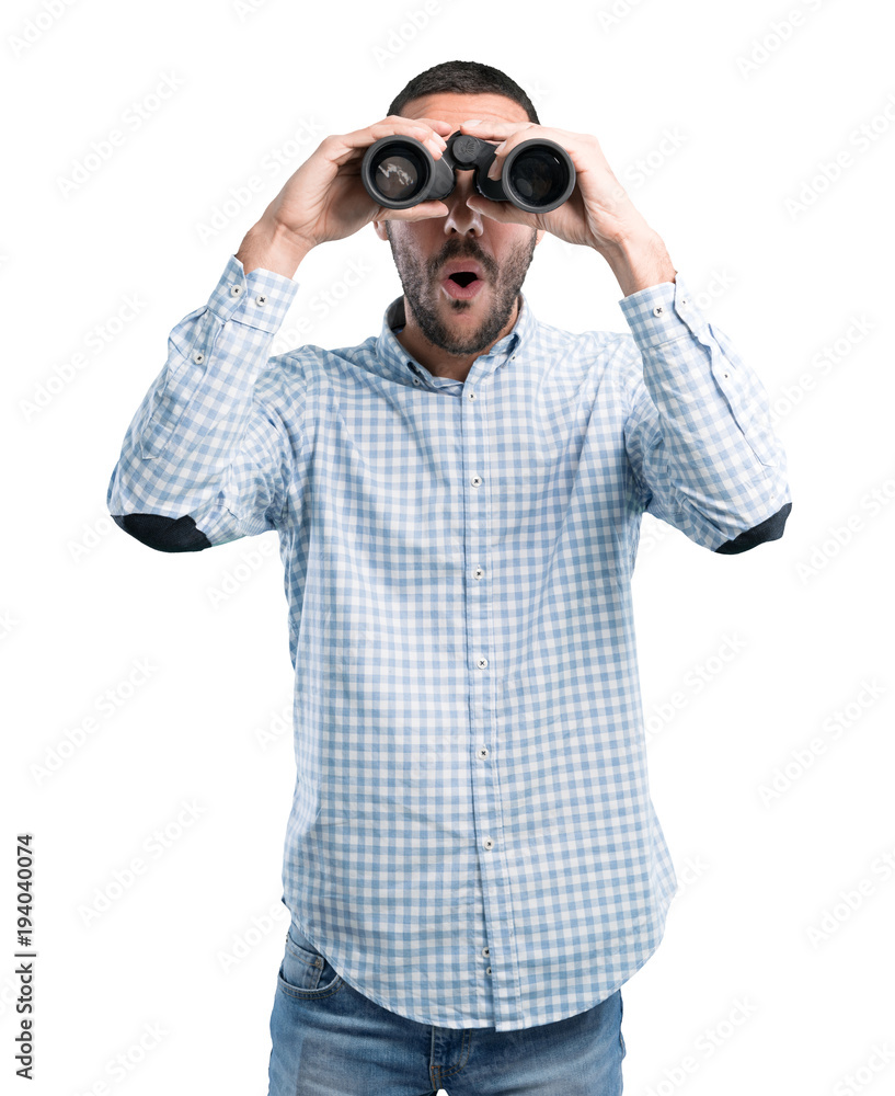 Surprised young man using a binoculars Surprised young man using a binoculars